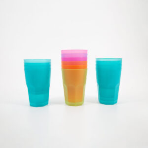 Tre pile di bicchieri in plastica riutilizzabili e colorati su sfondo bianco. Due pile sono turchesi, una centrale è multicolore.