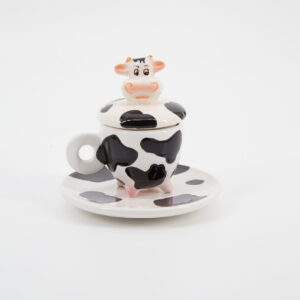 Set in ceramica bianco e nero con fantasia muccata, composto da tazza con zampe, coperchio con testa di mucca e piattino abbinato.