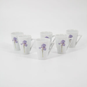Sei tazzine da caffè in ceramica bianca con manico triangolare e decorazione di un fiore di iris viola, disposte su sfondo bianco.