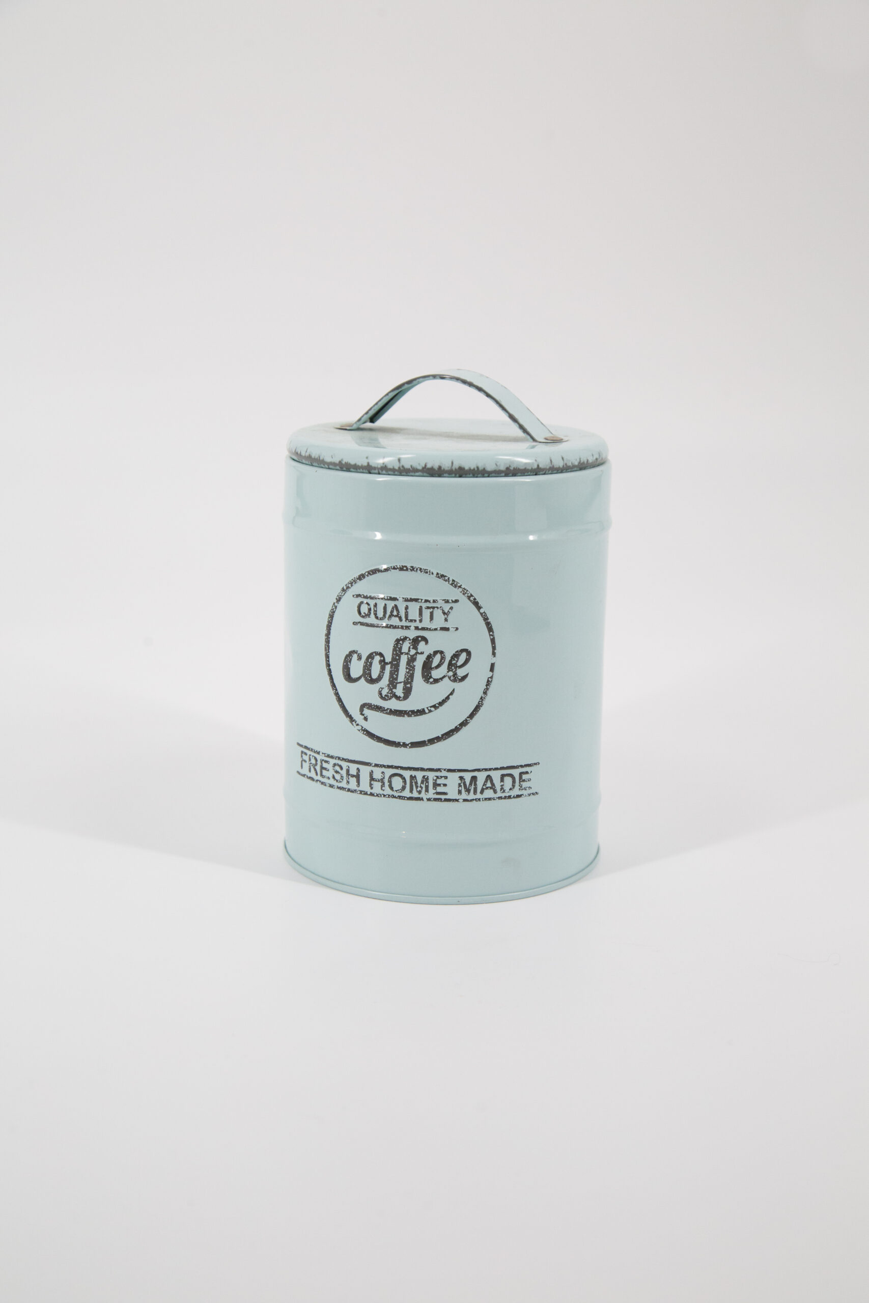 Barattolo cilindrico in metallo azzurro pastello con coperchio e maniglia, decorato con scritte "QUALITY coffee FRESH HOME MADE" in stile vintage.