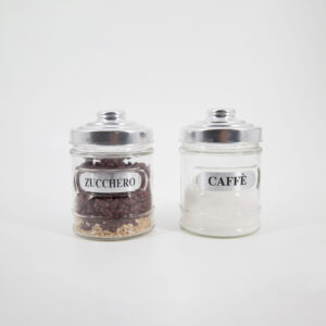 Due barattoli in vetro trasparente con coperchi metallici, etichettati "ZUCCHERO" e "CAFFÈ", su sfondo bianco.