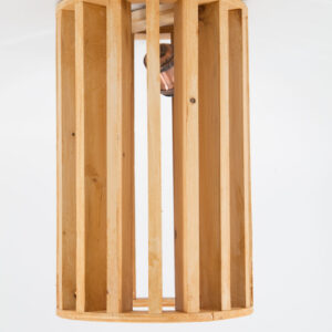 Paralume a sospensione cilindrico in legno chiaro a listelli verticali, con lampadina visibile all'interno, su sfondo bianco.