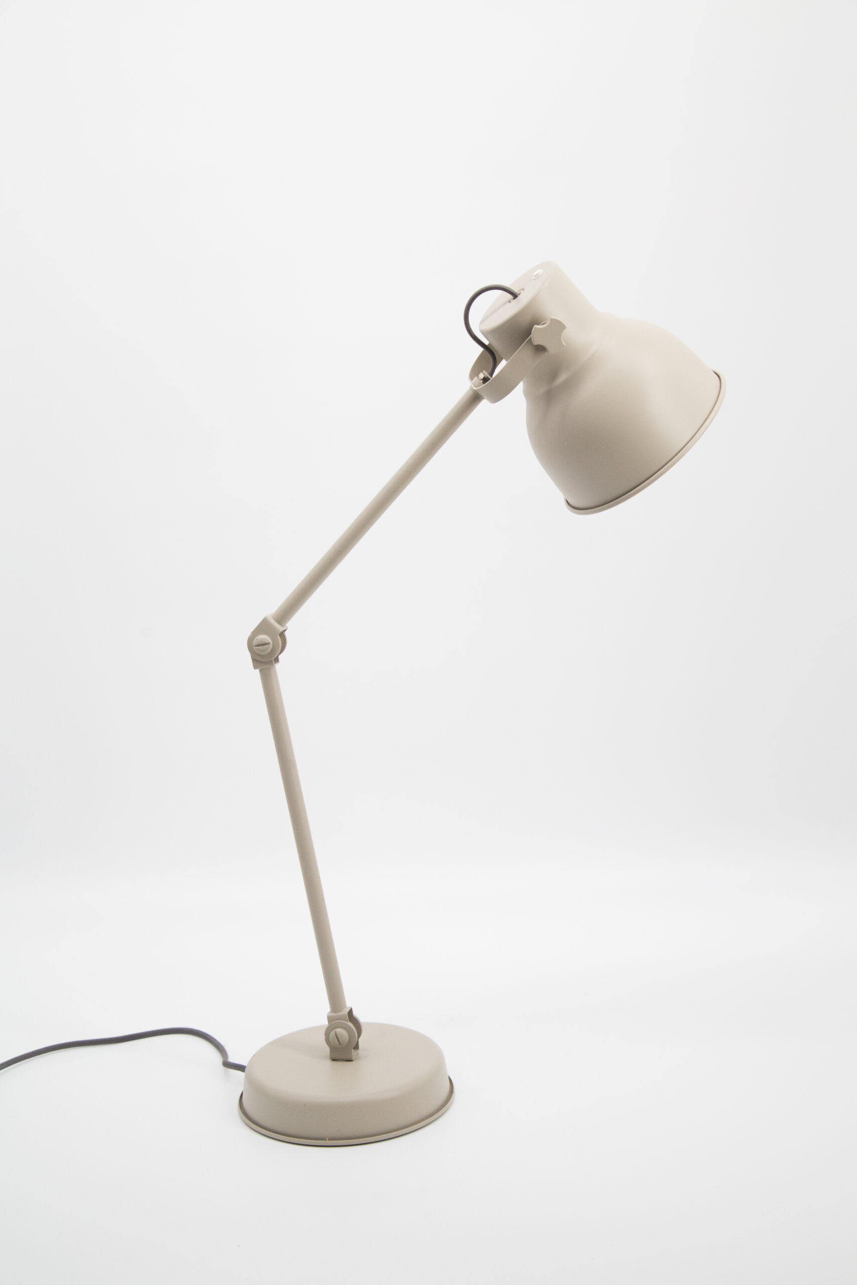 Lampada da tavolo articolata di colore beige chiaro su sfondo bianco, con braccio regolabile e paralume conico.
