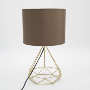Lampada da tavolo con base geometrica in metallo color oro e paralume cilindrico marrone su sfondo bianco.