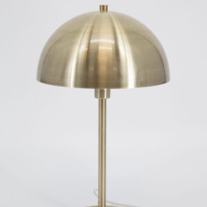 Lampada da tavolo moderna con paralume a cupola in finitura ottone spazzolato su sfondo bianco.