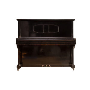 Pianoforte verticale vintage di colore nero con finitura opaca e segni di usura, dotato di tre pedali e rotelle, su sfondo bianco.