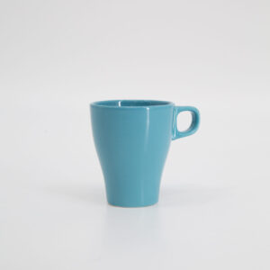 Tazza in ceramica di colore azzurro pastello, con forma svasata e manico, fotografata su sfondo bianco.