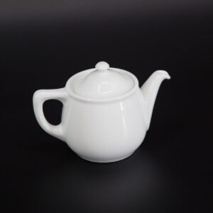 Teiera classica in ceramica bianca lucida con coperchio, posizionata centralmente su uno sfondo scuro e uniforme.