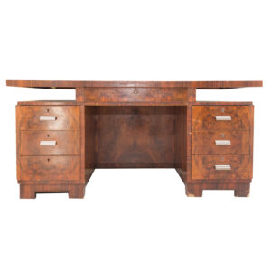 Scrivania direzionale vintage in radica di noce con sei cassetti laterali e uno centrale, maniglie metalliche cromate, su sfondo bianco.