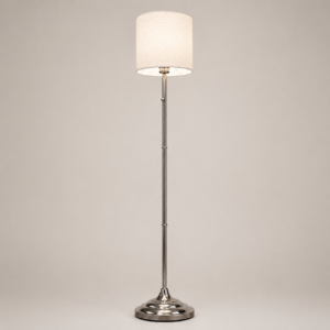 Lampada da terra classica con fusto in metallo lucido e paralume cilindrico in tessuto chiaro con trama, su sfondo neutro.