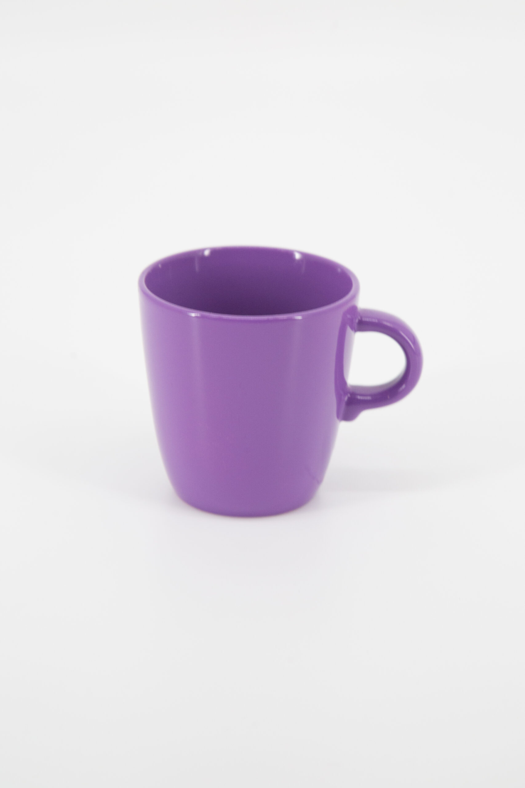 Tazza singola in ceramica di colore viola intenso, con manico, su sfondo bianco neutro, vista frontale.