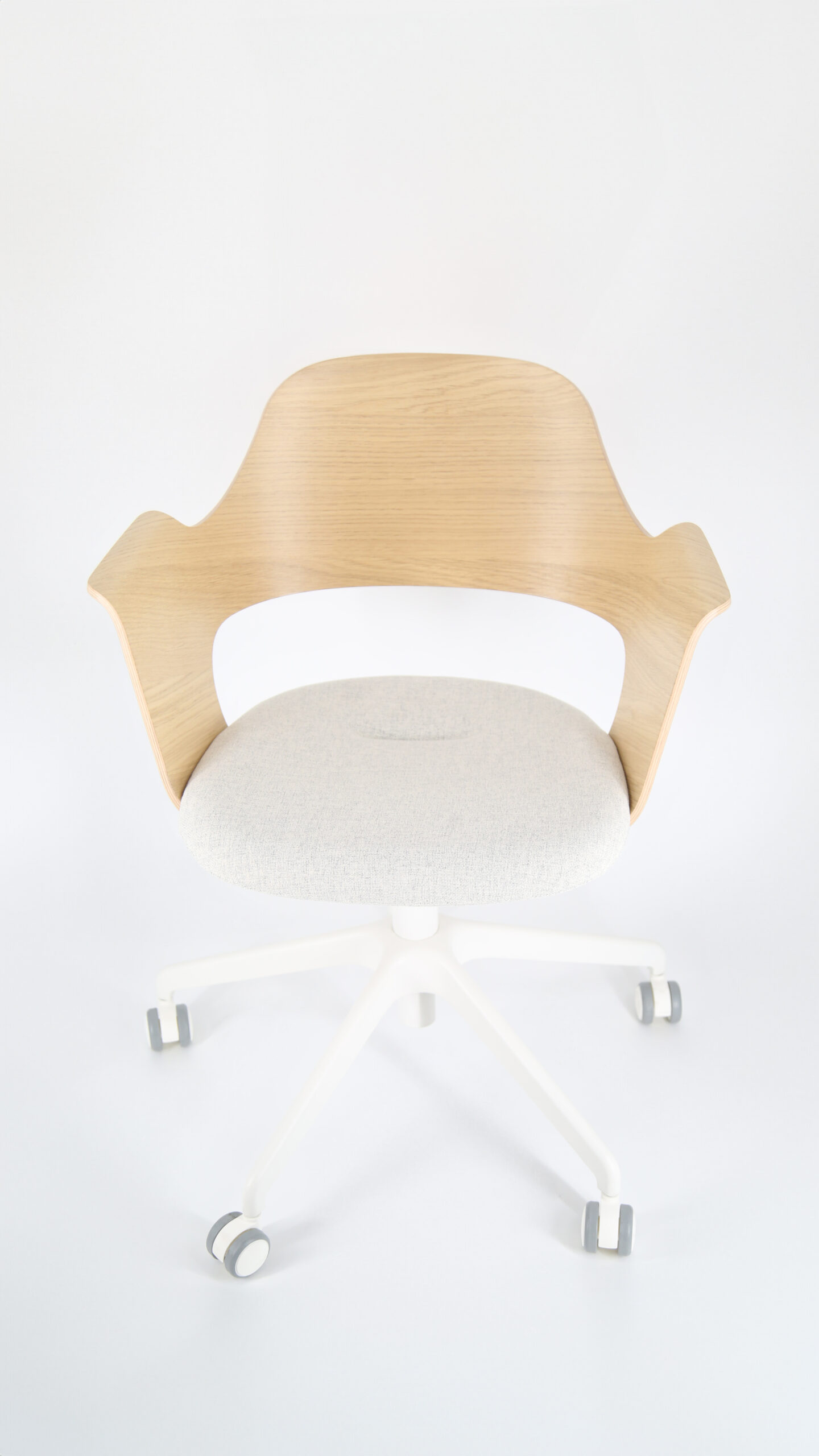 Sedia da ufficio moderna con schienale in legno chiaro curvato, seduta imbottita grigia e base bianca a cinque razze con ruote.