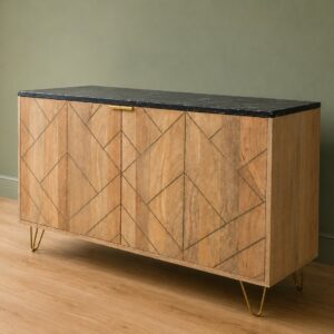 Madia moderna in legno chiaro con intarsi geometrici, piano in marmo nero e gambe a forcina dorate, su pavimento in legno.