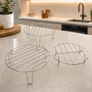 Tre griglie circolari in metallo di diverse dimensioni, posizionate su un bancone da cucina moderno e luminoso.