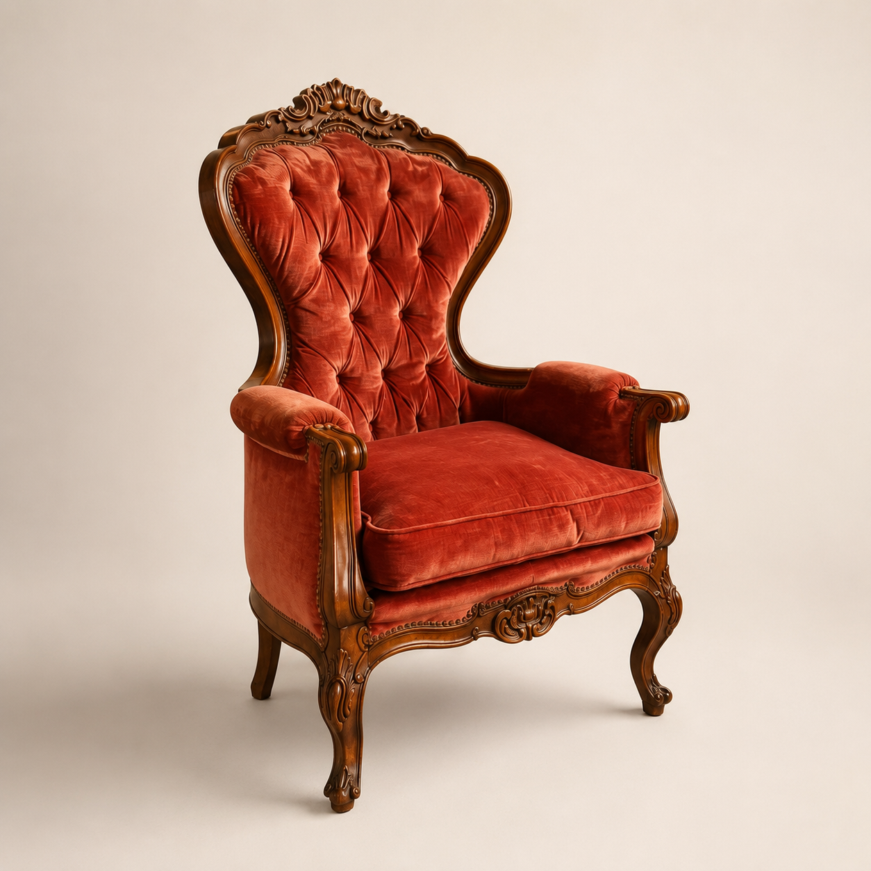 Poltrona barocca con schienale alto, rivestita in velluto rosso capitonné e struttura in legno intagliato, su sfondo neutro.