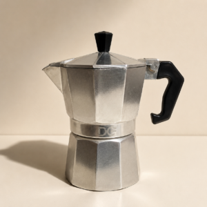 Caffettiera moka in alluminio con manico e pomello neri, posizionata su una superficie chiara con sfondo beige.