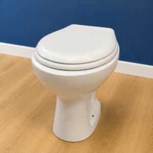 Vaso WC standard in ceramica bianca con coperchio chiuso, posizionato su pavimento in legno chiaro davanti a parete blu.