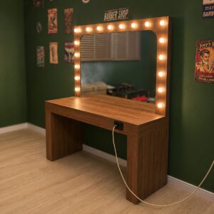 Specchiera trucco illuminata con lampadine LED e tavolo in legno marrone, posizionata in una stanza con pareti verdi.