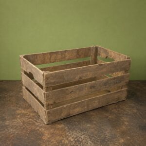 Cassetta in legno scuro, rustica e invecchiata, con doghe orizzontali e maniglie intagliate, su sfondo verde e superficie scura.
