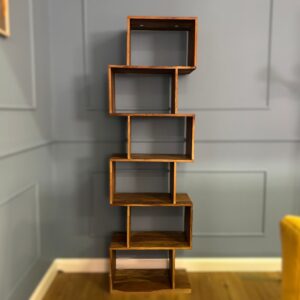 Scaffale alto e stretto in legno massello con sei scomparti aperti disposti a zig-zag su una parete grigia.