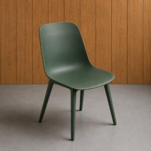 Sedia monoscocca moderna di colore verde scuro opaco, con design minimalista e quattro gambe integrate, su sfondo di pannelli in legno e pavimento grigio.