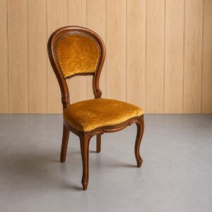 Sedia vintage Luigi XV con struttura in legno scuro intagliato e rivestimento in velluto giallo ocra, con borchie decorative.