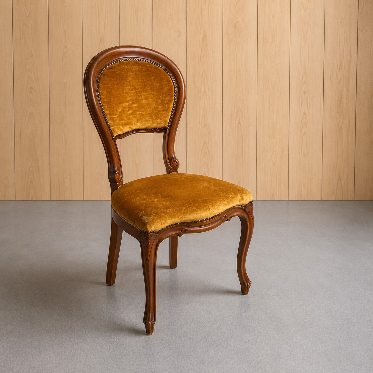 Sedia vintage Luigi XV con struttura in legno scuro intagliato e rivestimento in velluto giallo ocra, con borchie decorative.
