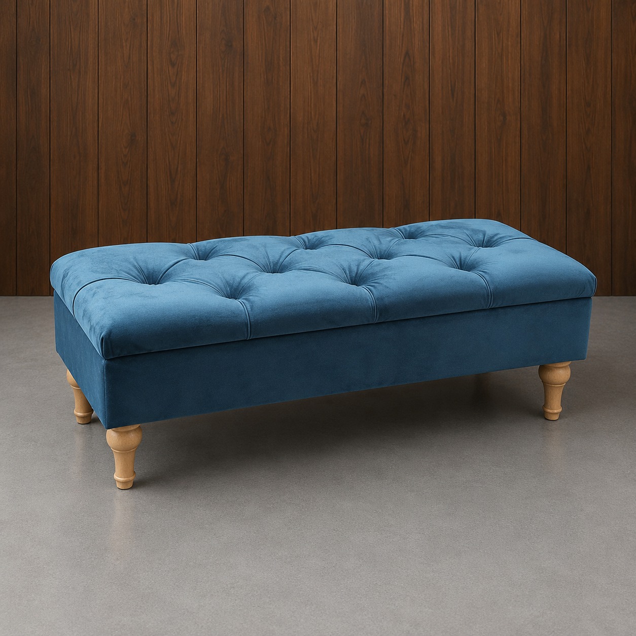 Panca contenitore rettangolare in velluto blu petrolio con lavorazione capitonné e quattro gambe tornite in legno chiaro, su sfondo in legno scuro.