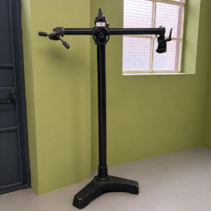 Stativo da studio professionale nero con base a treppiede e braccio orizzontale regolabile, marchio FATH, su sfondo verde.
