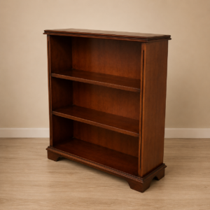 Libreria classica in legno scuro con tre ripiani vuoti, posta su un pavimento in legno chiaro davanti a una parete beige.