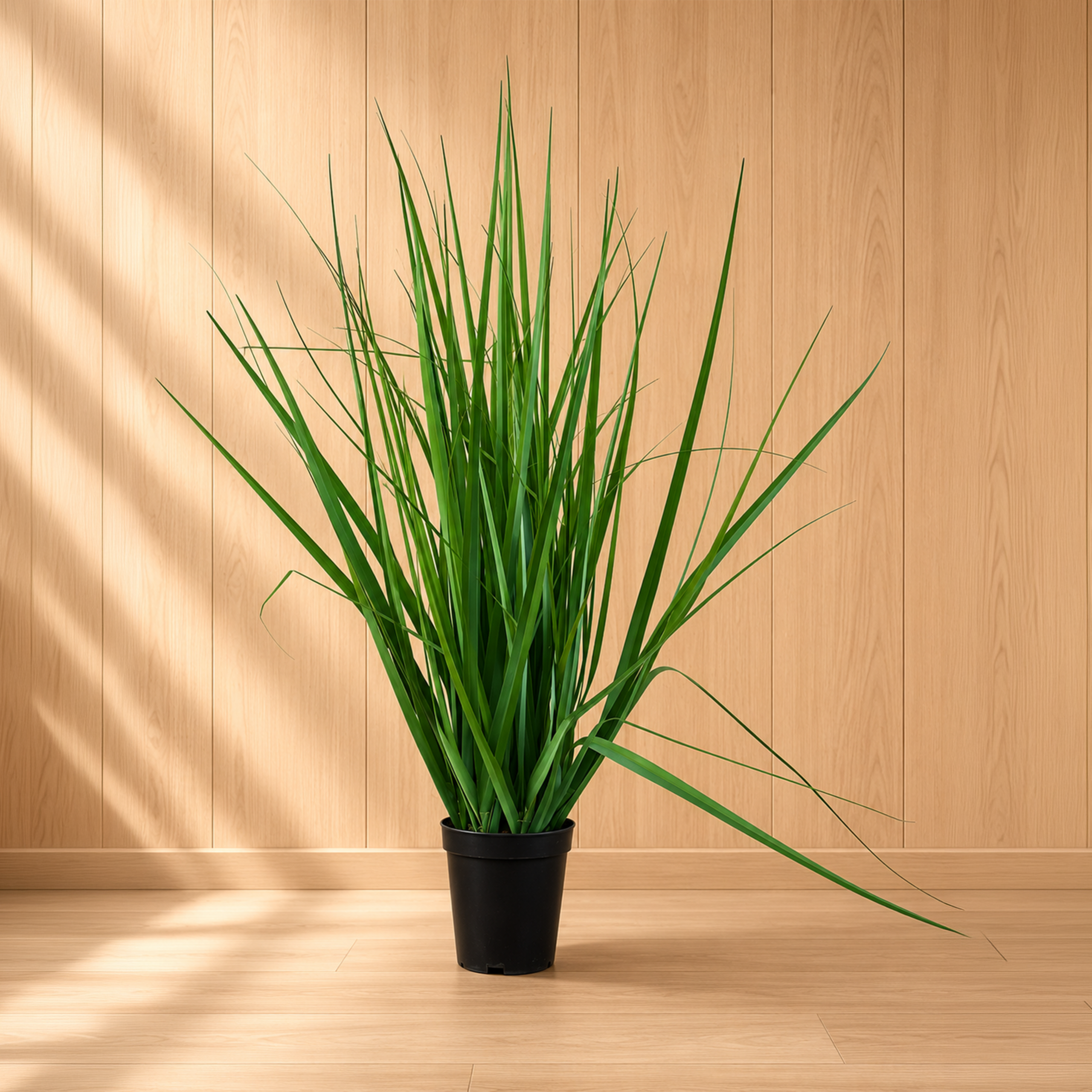 Pianta artificiale di erba alta e verde in un vaso nero, posizionata su un pavimento in legno chiaro con una parete a pannelli in legno sullo sfondo.