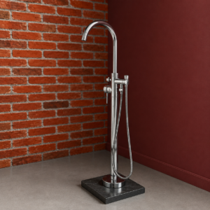 Miscelatore vasca freestanding cromato lucido con doccetta su base in marmo scuro, posizionato tra una parete in mattoni e una rossa.