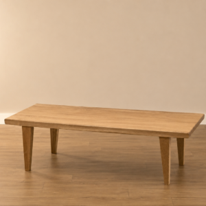 Tavolino basso rettangolare in legno massello chiaro con gambe affusolate, posizionato su pavimento in parquet davanti a una parete beige.
