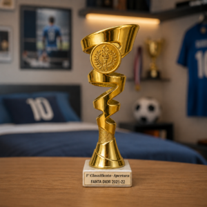 Trofeo dorato lucido con design a spirale e medaglione, poggiato su una base quadrata effetto marmo bianco con targa incisa.