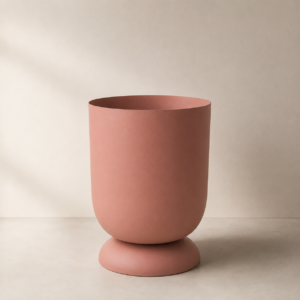 Vaso cilindrico alto color terracotta opaco con base arrotondata, su sfondo neutro con ombra laterale.